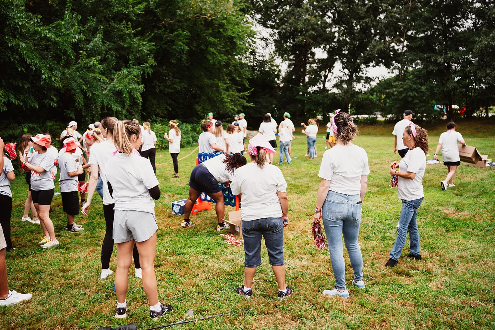 Team bonding at the annual Olympics in custom tees playing outdoor Connect Four.